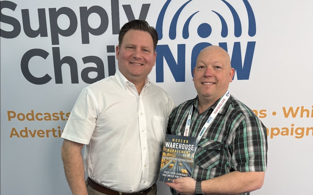 Will Quinn holding a copy of Modern Warehouse Management at the Supply Chain Now studio backdrop